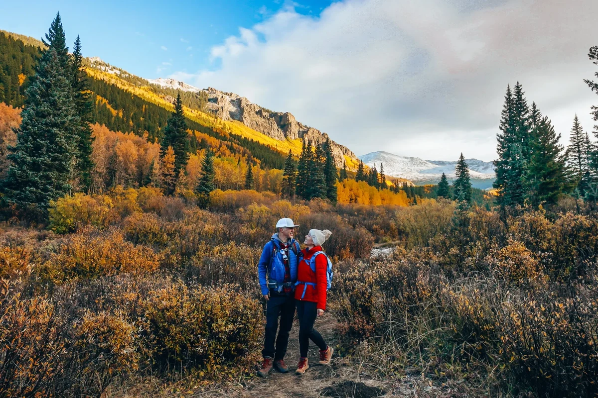 Hiker enjoying breathtaking views of Colorado mountains on a trail.