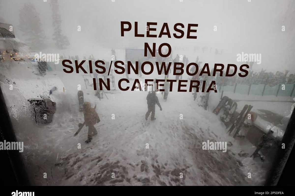 Person sizing a snowboard based on weight and height in a snowy landscape.