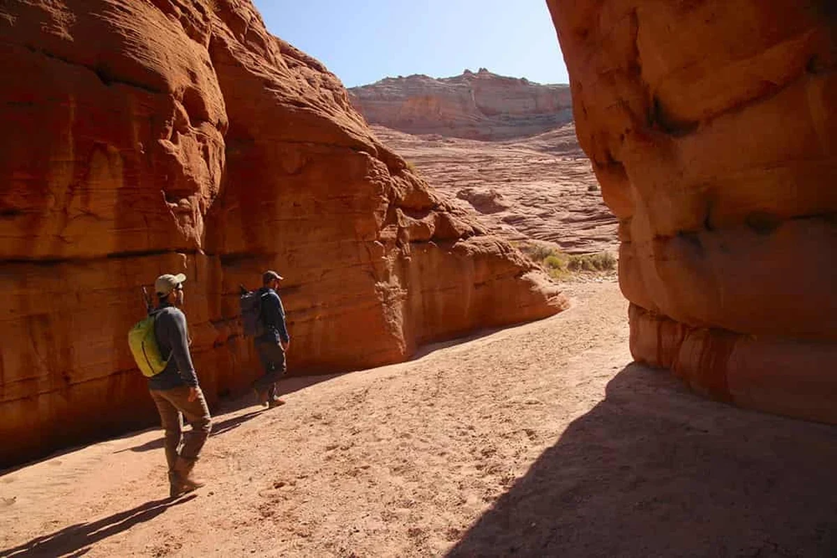 Two hikers on opposite sides of a canyon exploring the trails.
