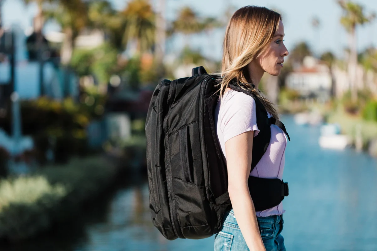 Woman using a travel backpack with laptop compartment in an airport