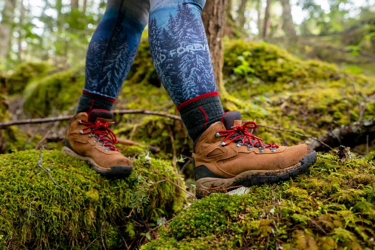 Hiking boots with red shoe strings on a rocky trail