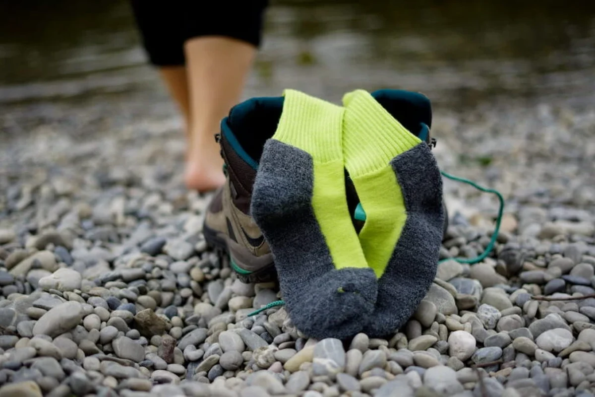 Hiking boots with red shoe strings on a rocky trail